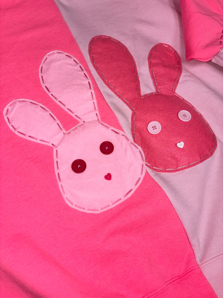 Close-up of a pink and hot pink crew neck with bunny patch 